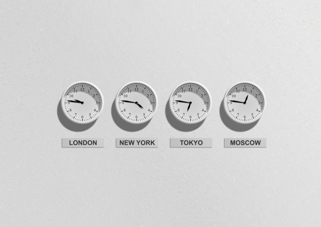 Four clocks showing different time zones for London, New York, Tokyo, and Moscow on a white wall